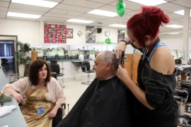 Vietnam veteran Robert Cace chats with cosmetology teacher Carolyn McKillop while getting his hair cut by a student. Photo: Courtney Blasl.