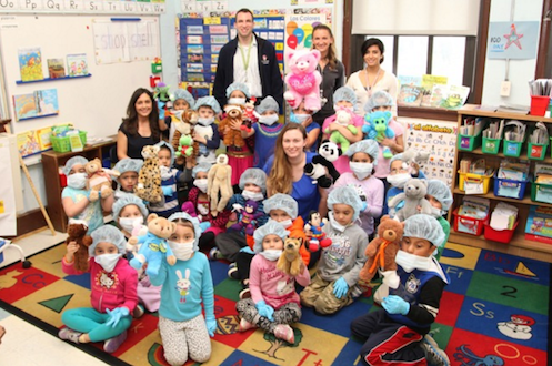 Kindergarten teacher Anselma Jimenez (seated far left with her students) and Teacher Assistant Marisa Mullane (middle in blue) with their kindergarten students. Also pictured in the back: L-R Dr. Noah Jablow, Kristi Landowski, MPH and Dr. Anupa Dalel from Stony Brook Trauma Center and Hospital. Courtesy photo