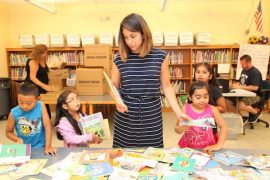 Courtesy photo: ENL teacher Souz Anna Anderson helping students choose books for their home libraries to read over the summer. Background Elisa Gattuso and Dan Vallance