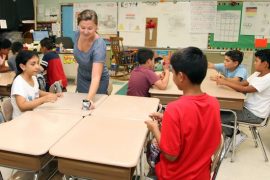 Courtesy photo: ENL teacher Tami Koller gives her students instructions on a timed game using chopsticks to grab and move pieces of paper.
