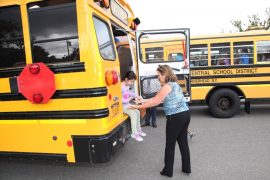 Colette Furcht, Transportation Co-Director helps a student during Phillips Avenue School's bus drill