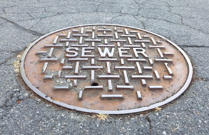 Sewer metal cap on the road in close up