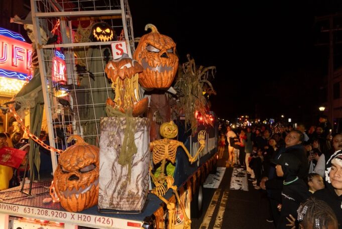 Halloween parade float makes its way down a crowded Main Street,