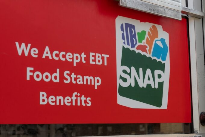 Grocery store window sign: SNAP and EBT Accepted here.