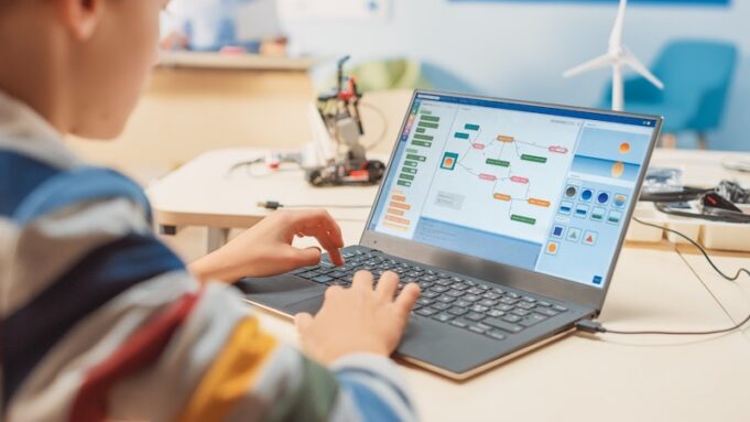 Student using laptop in class AdobeStock